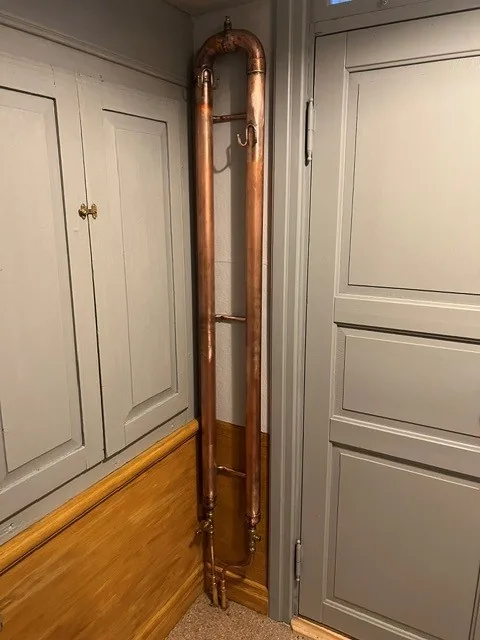 Specialtillverkad radiator i koppar monterad i en hall av Rörteknik i Bollnäs.
